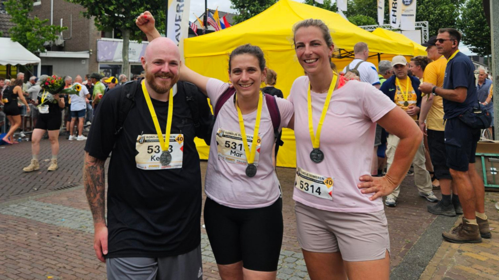 Kevin, Mar en Marjolein lopen samen over de finish van de Kennedymars na 40 kilometer.